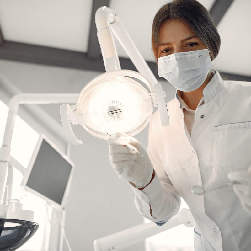 Woman in a uniform. Doctor working at the clinic. Dentist holds a tools in her hands